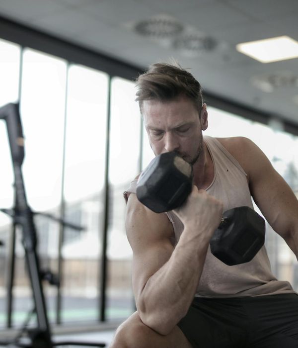 Man focused on a strength exercise in a well-lit space.